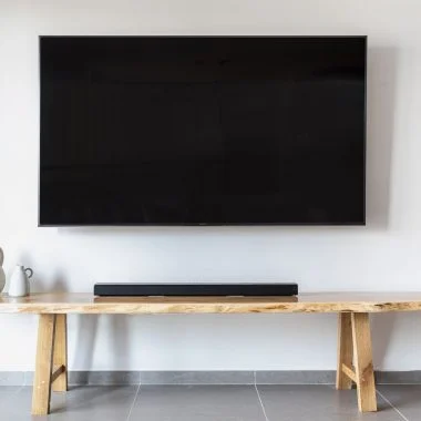 a flat screen tv mounted on wall over a wooden console