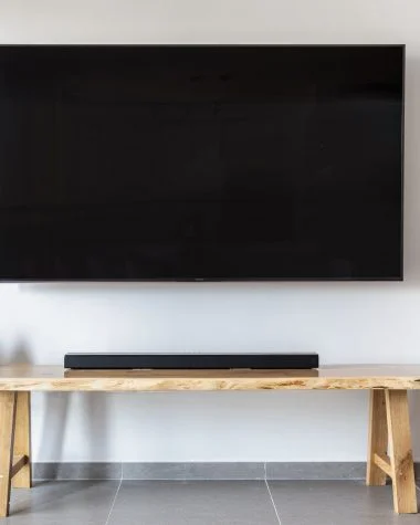 a flat screen tv mounted on wall over a wooden console