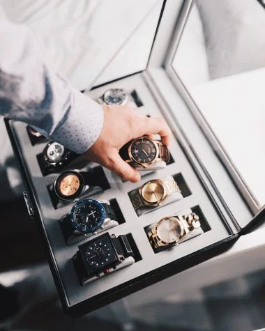 person holding round gold colored analog watch with link bracelet