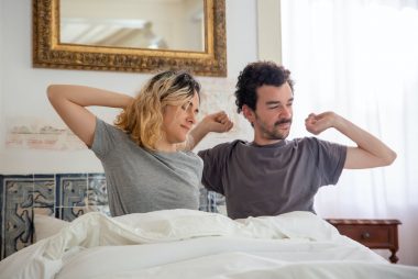 couple stretching in bed