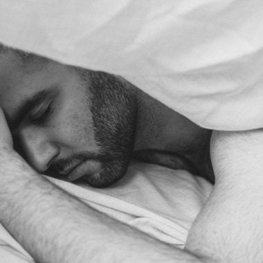 serene man sleeping under blanket